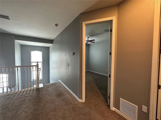 hall with carpet and a textured ceiling