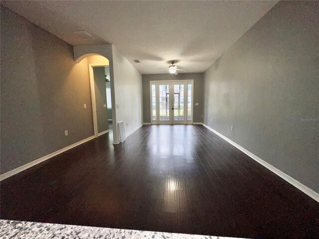 spare room with ceiling fan, french doors, and dark hardwood / wood-style floors