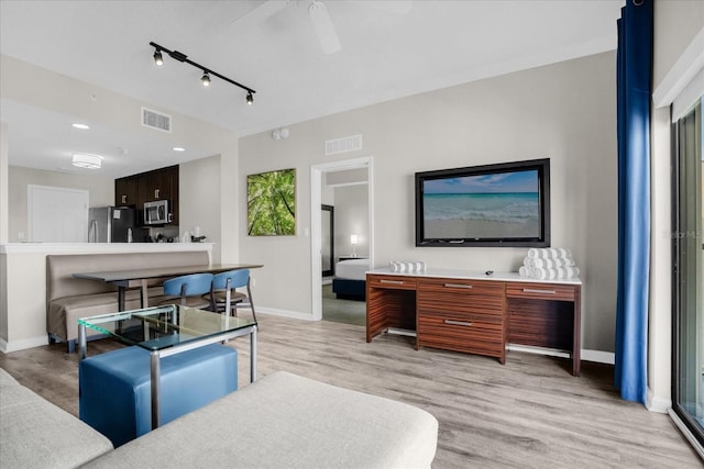 living room featuring light wood-style floors, baseboards, visible vents, and ceiling fan