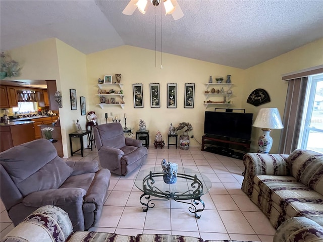 living room featuring light tile patterned floors, a textured ceiling, ceiling fan, and lofted ceiling