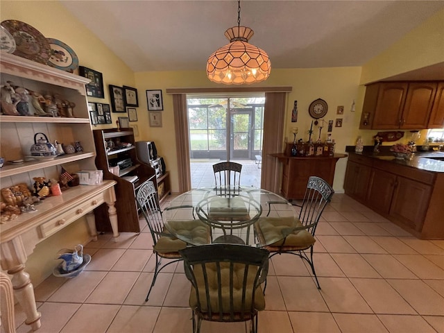 dining area with light tile patterned floors and vaulted ceiling