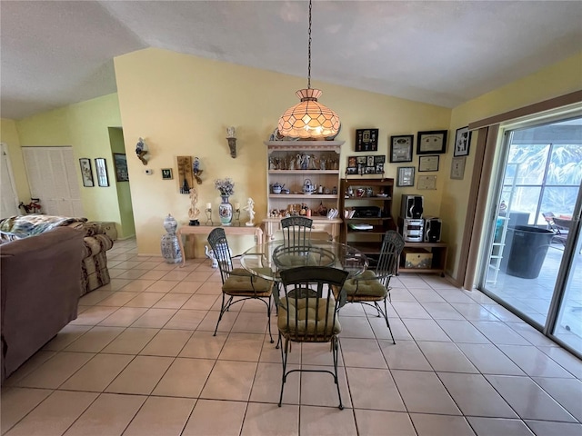 tiled dining room with lofted ceiling