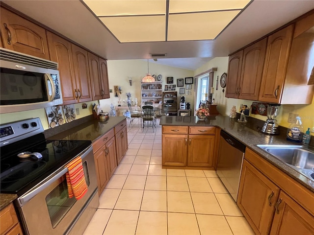 kitchen featuring kitchen peninsula, pendant lighting, light tile patterned floors, and stainless steel appliances