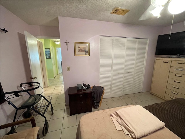 tiled bedroom featuring a textured ceiling, a closet, and ceiling fan