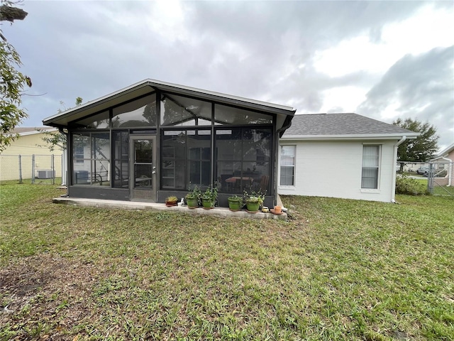 back of property featuring a lawn, central AC, and a sunroom