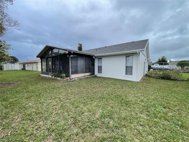 rear view of house featuring a sunroom and a yard