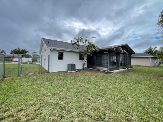 back of house with a lawn, central AC, and a sunroom