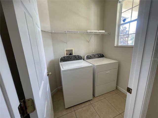 clothes washing area with washer and dryer and light tile patterned floors