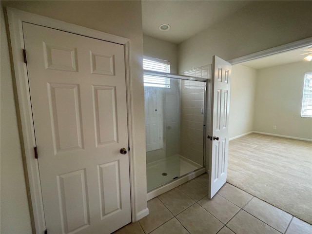 bathroom featuring a wealth of natural light, tile patterned floors, and a shower with shower door