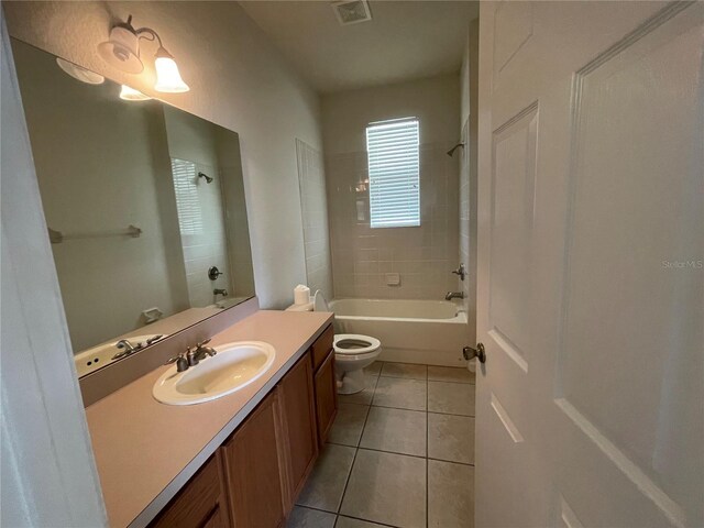 full bathroom featuring tiled shower / bath combo, toilet, tile patterned flooring, and vanity