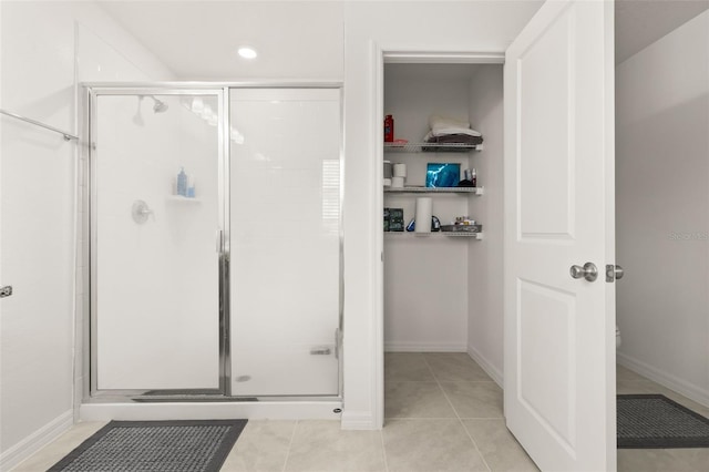 bathroom with an enclosed shower and tile patterned floors