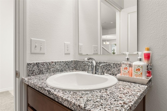 bathroom with vanity and a chandelier