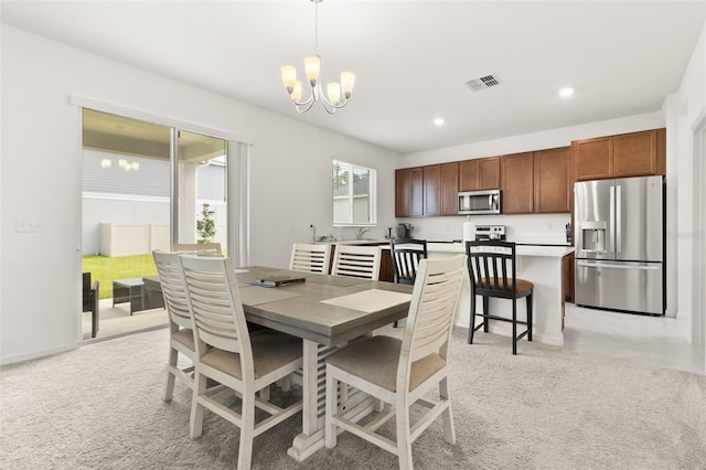 dining space featuring a chandelier and sink