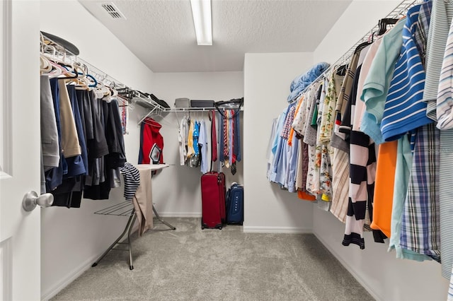 walk in closet featuring carpet flooring