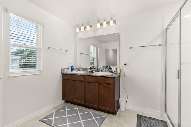 bathroom with vanity, a shower with shower door, and tile patterned floors