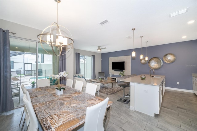 dining room featuring light tile patterned floors, ceiling fan with notable chandelier, and sink