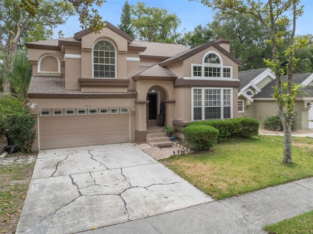 view of front of property featuring stucco siding, driveway, a front yard, a shingled roof, and a garage