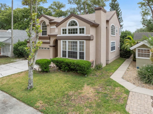 view of front facade featuring driveway, a chimney, stucco siding, a front lawn, and a garage