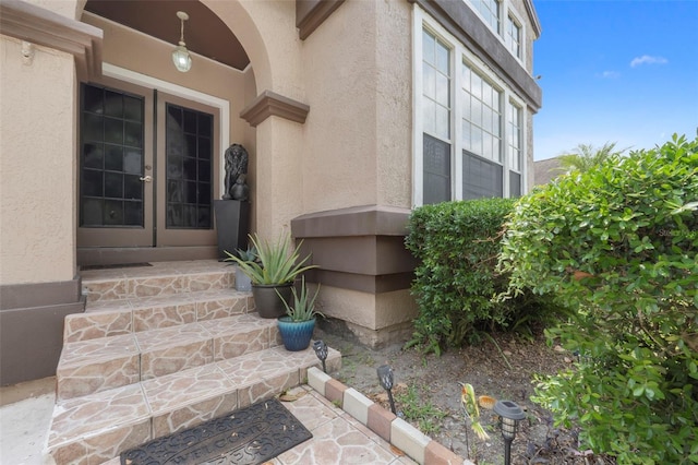 entrance to property with french doors and stucco siding