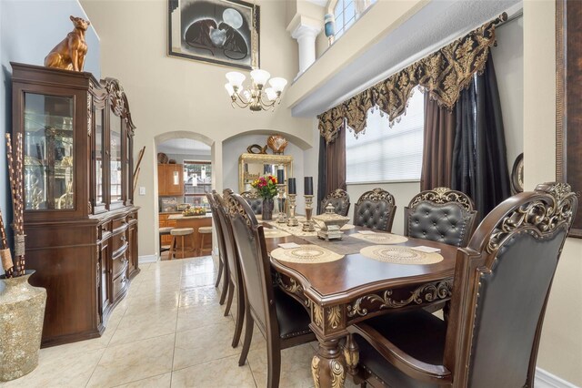 dining room with light tile patterned floors, a high ceiling, and a chandelier