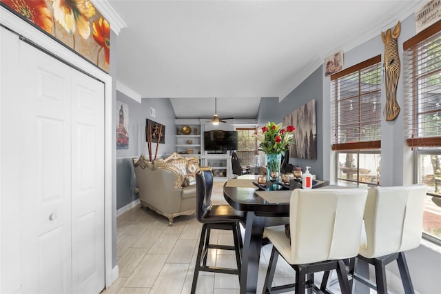 dining area with ceiling fan, light wood-type flooring, vaulted ceiling, and crown molding