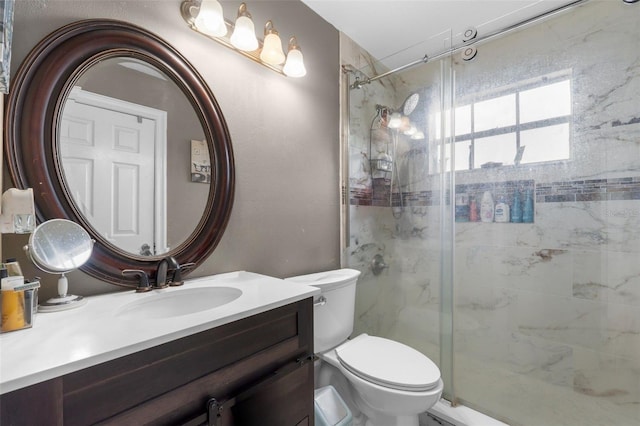 bathroom with a shower with shower door, toilet, and vanity