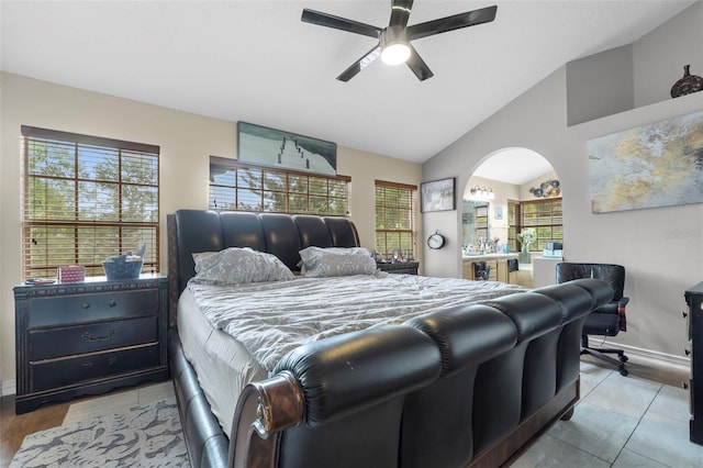 bedroom with ceiling fan, vaulted ceiling, multiple windows, and light tile patterned floors