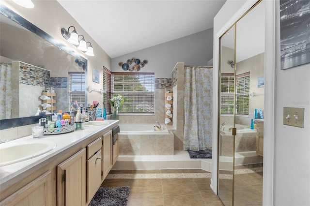 bathroom with tile patterned flooring, vaulted ceiling, a healthy amount of sunlight, and vanity