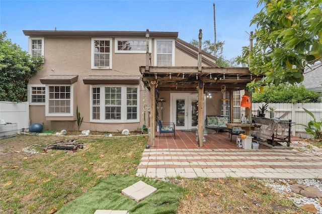 rear view of property featuring a patio, french doors, and a yard