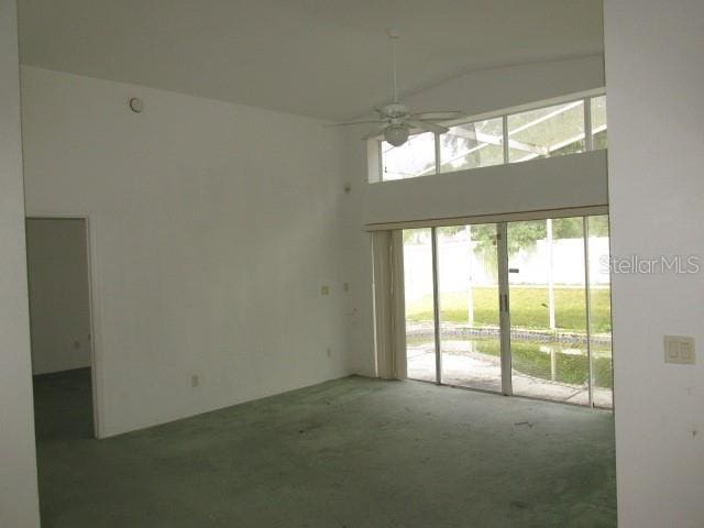 unfurnished room with high vaulted ceiling and a ceiling fan