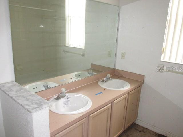 bathroom with a sink and double vanity