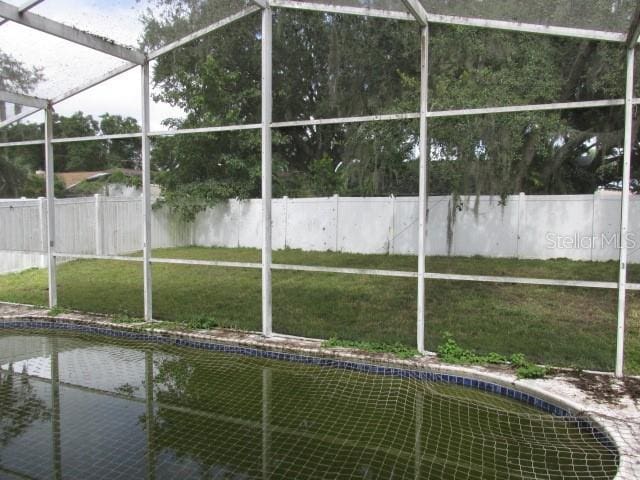 exterior space featuring a yard, a lanai, and fence