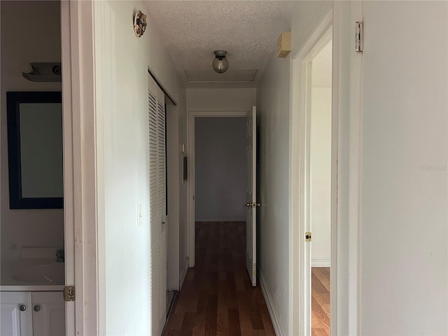 hall featuring a textured ceiling and dark hardwood / wood-style floors