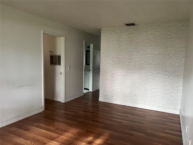 unfurnished room with dark hardwood / wood-style flooring