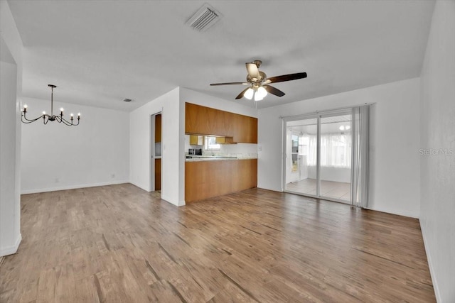 kitchen with light wood finished floors, visible vents, light countertops, and open floor plan