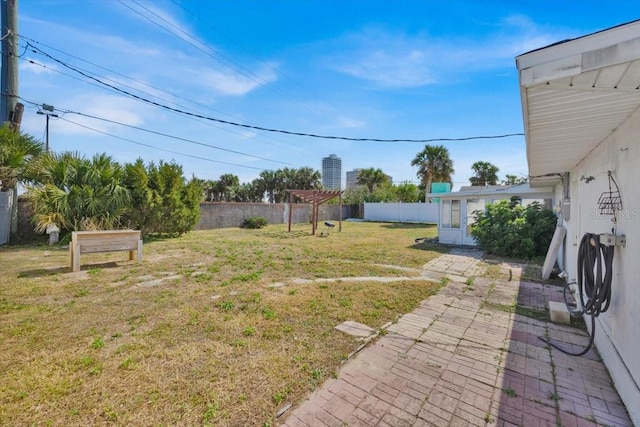 view of yard with a patio area, a fenced backyard, and a pergola