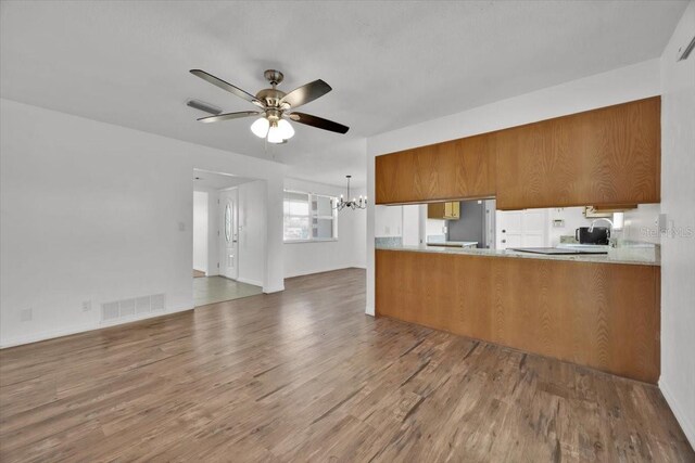 kitchen featuring a peninsula, light countertops, dark wood finished floors, and visible vents