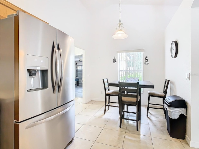 kitchen with stainless steel fridge with ice dispenser, hanging light fixtures, and light tile patterned floors