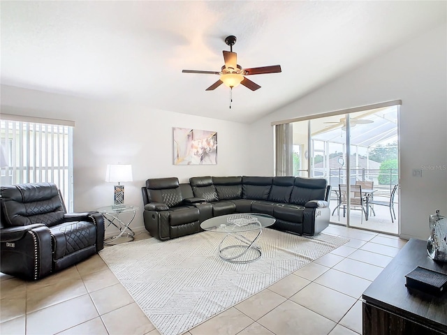 living room with ceiling fan, light tile patterned flooring, and lofted ceiling