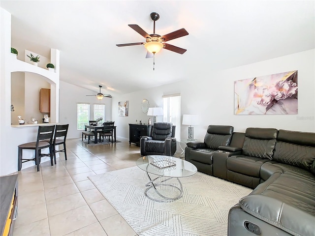 living room featuring ceiling fan, vaulted ceiling, and light tile patterned floors