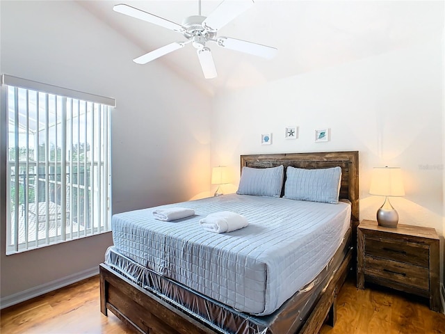 bedroom with ceiling fan, lofted ceiling, and hardwood / wood-style floors