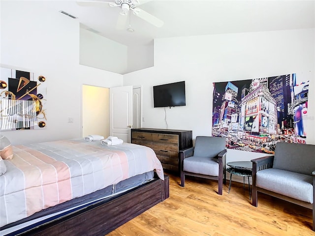 bedroom featuring ceiling fan, light wood-type flooring, and high vaulted ceiling