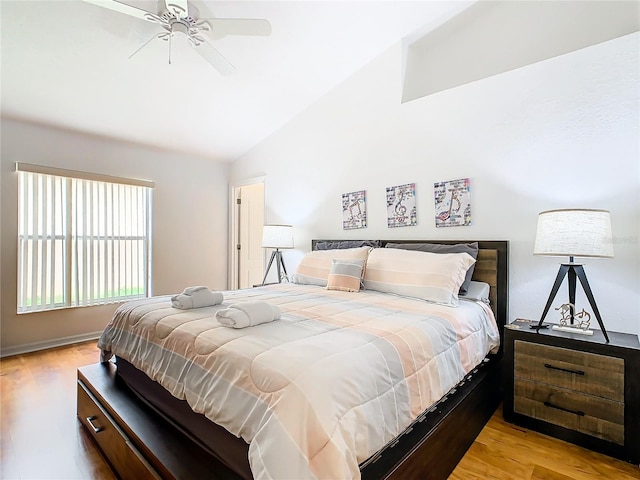 bedroom with ceiling fan, lofted ceiling, and light wood-type flooring