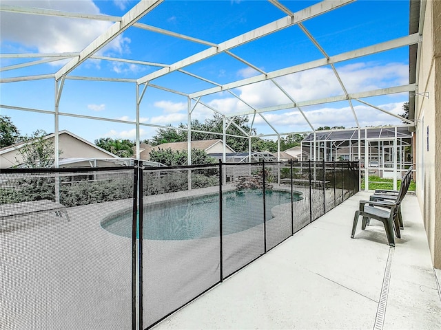 view of swimming pool featuring glass enclosure and a patio