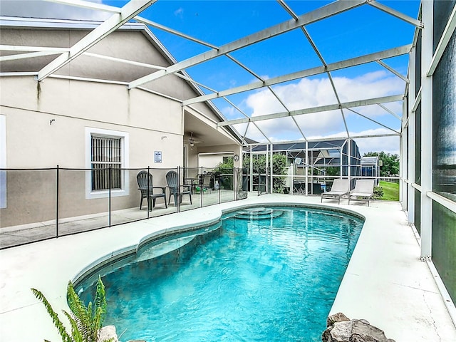 view of pool with ceiling fan, a patio area, and a lanai