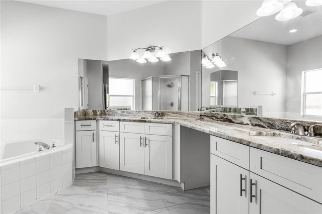 bathroom featuring vanity, a chandelier, and shower with separate bathtub