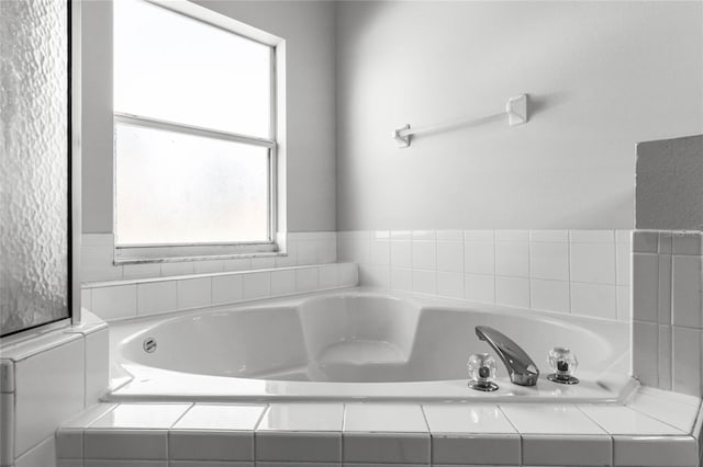 bathroom featuring tiled tub