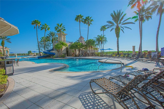 view of swimming pool with a water slide and a patio area