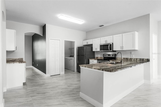 kitchen featuring washer and dryer, kitchen peninsula, sink, appliances with stainless steel finishes, and white cabinets