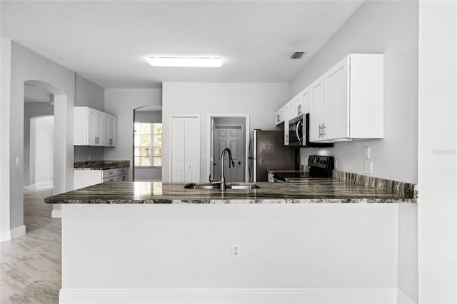 kitchen featuring appliances with stainless steel finishes, white cabinetry, kitchen peninsula, and sink